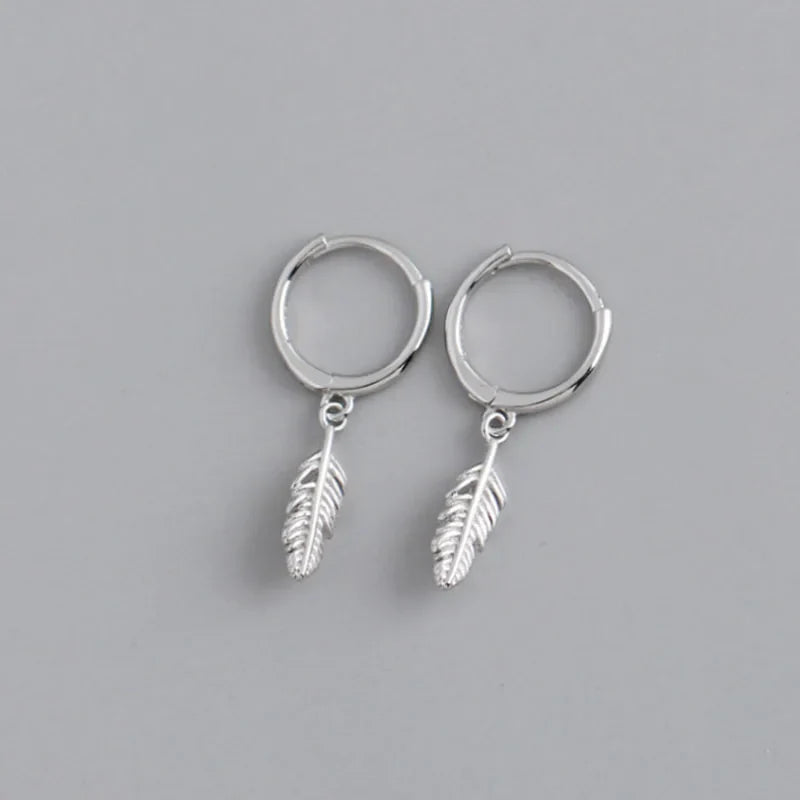 Hoop earrings with a small dangling feather