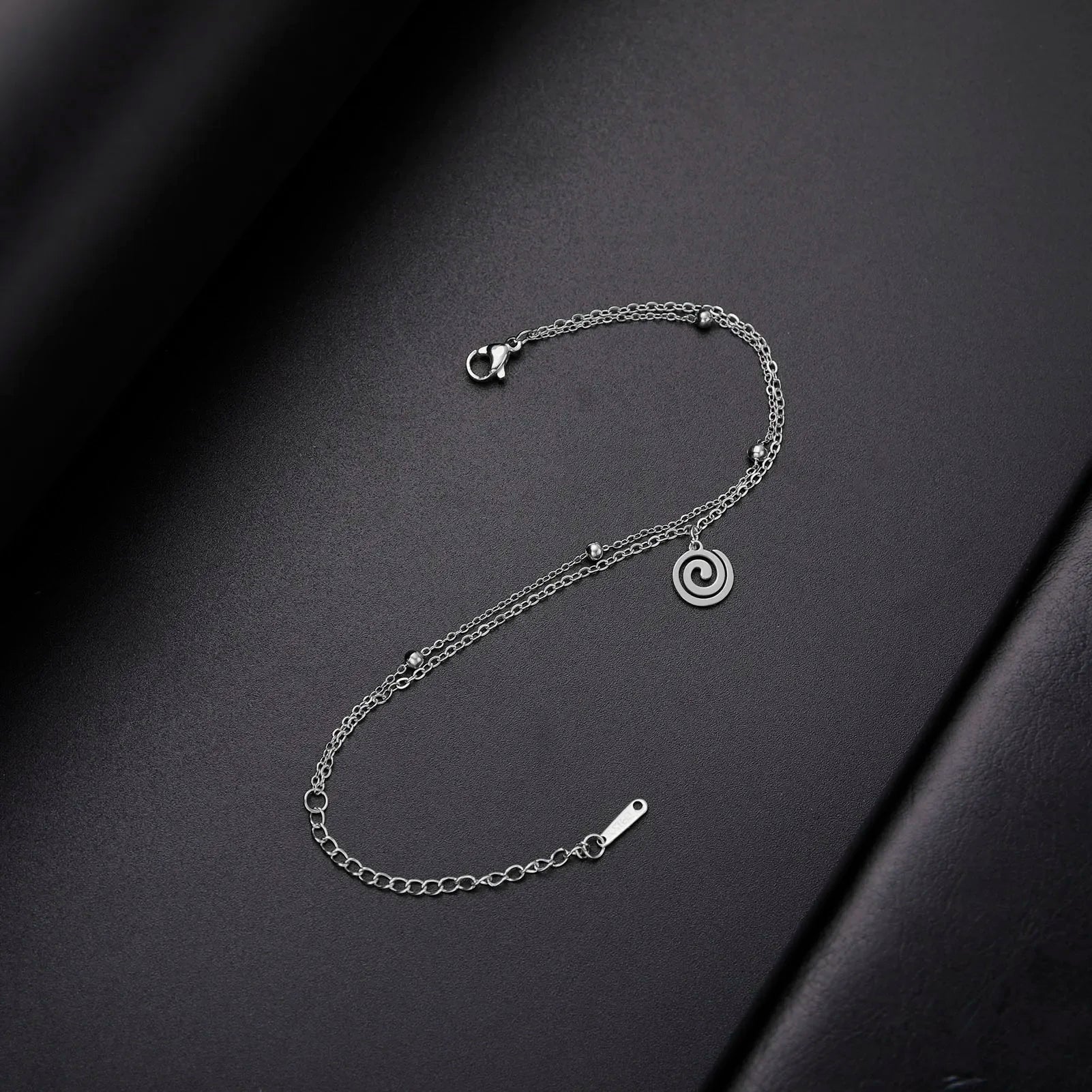 Bracelet doré avec petite breloque spirale argent