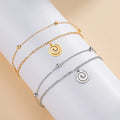 Bracelet doré avec petite breloque spirale or