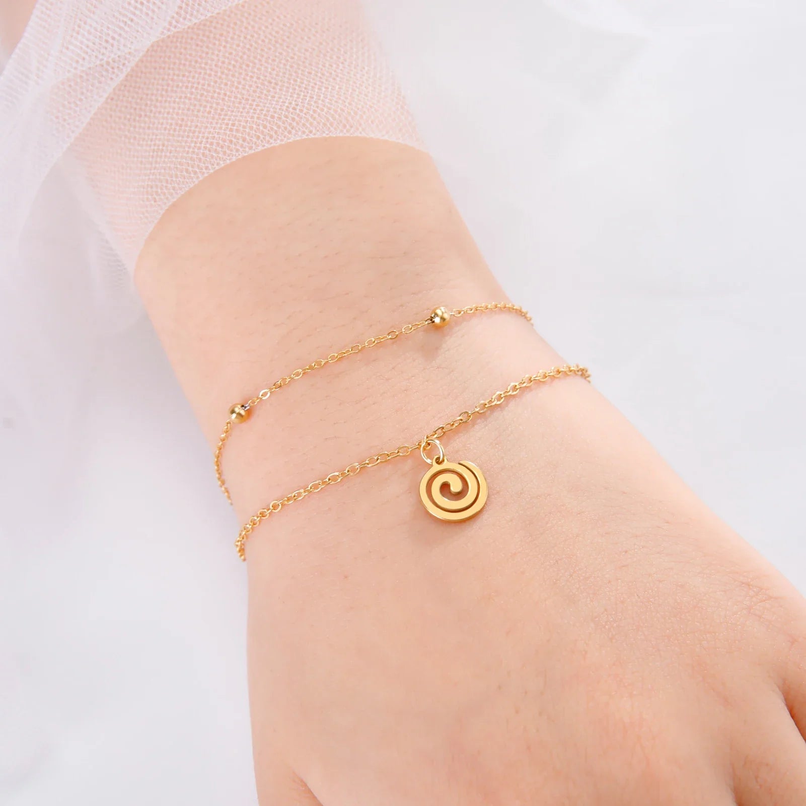 Bracelet doré avec petite breloque spirale or