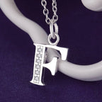 Collier long avec pendentif initiale f
